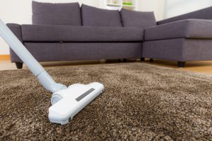 white vacuum cleaning a brown rug