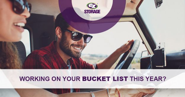 Couple wearing sunglasses in a car reading a map smiling and text "Working on your bucketlist this year?"