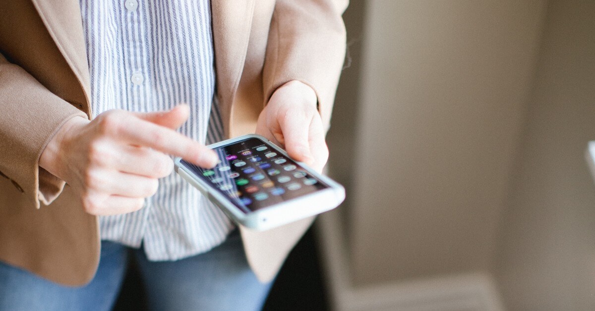 Close up of professional woman's hands holding an iPhone.