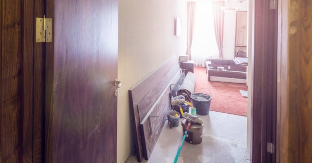 View of an apartment with open door with remodeling supplies.