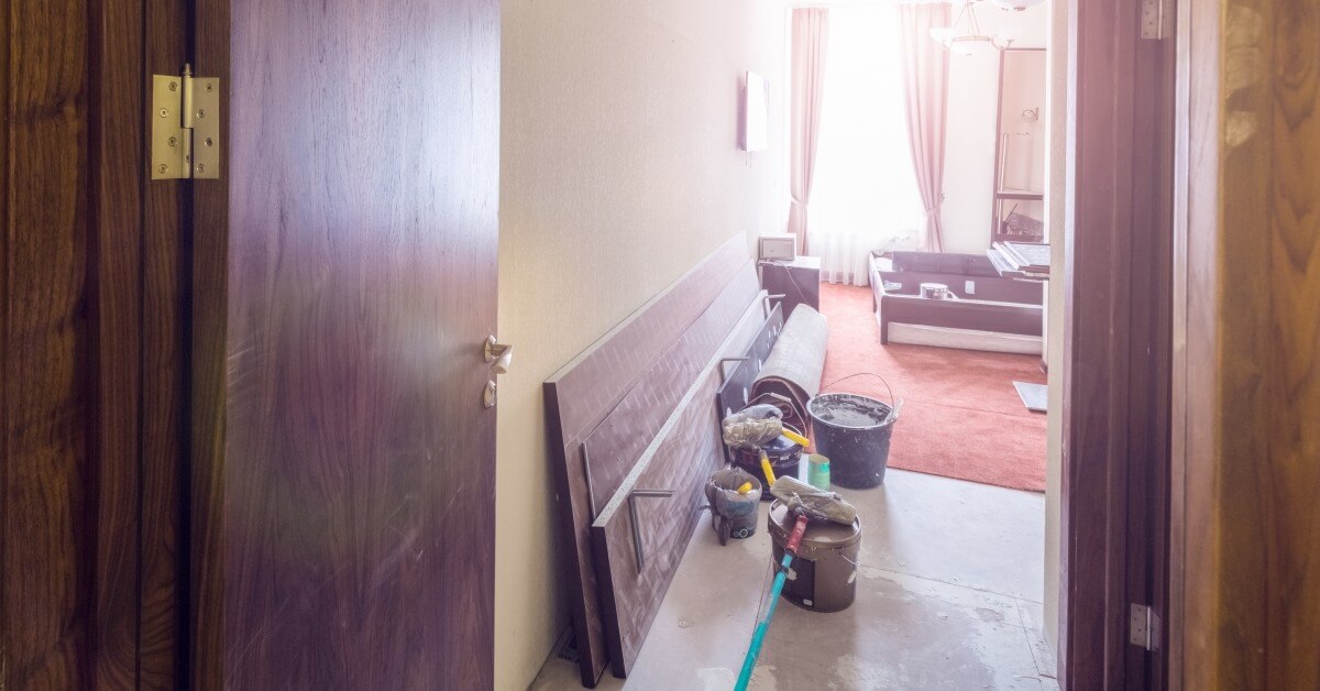 View of an apartment with open door with remodeling supplies.