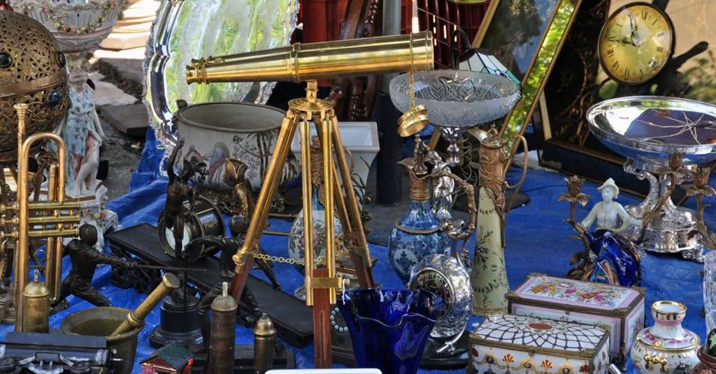 Closeup of valuable items: telescope, glass vases, ceramic jewlery box and other antiques