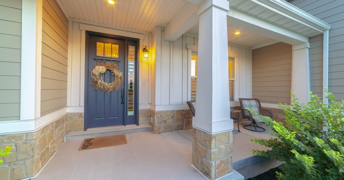 Exterior shot of front door and patio space with furniture